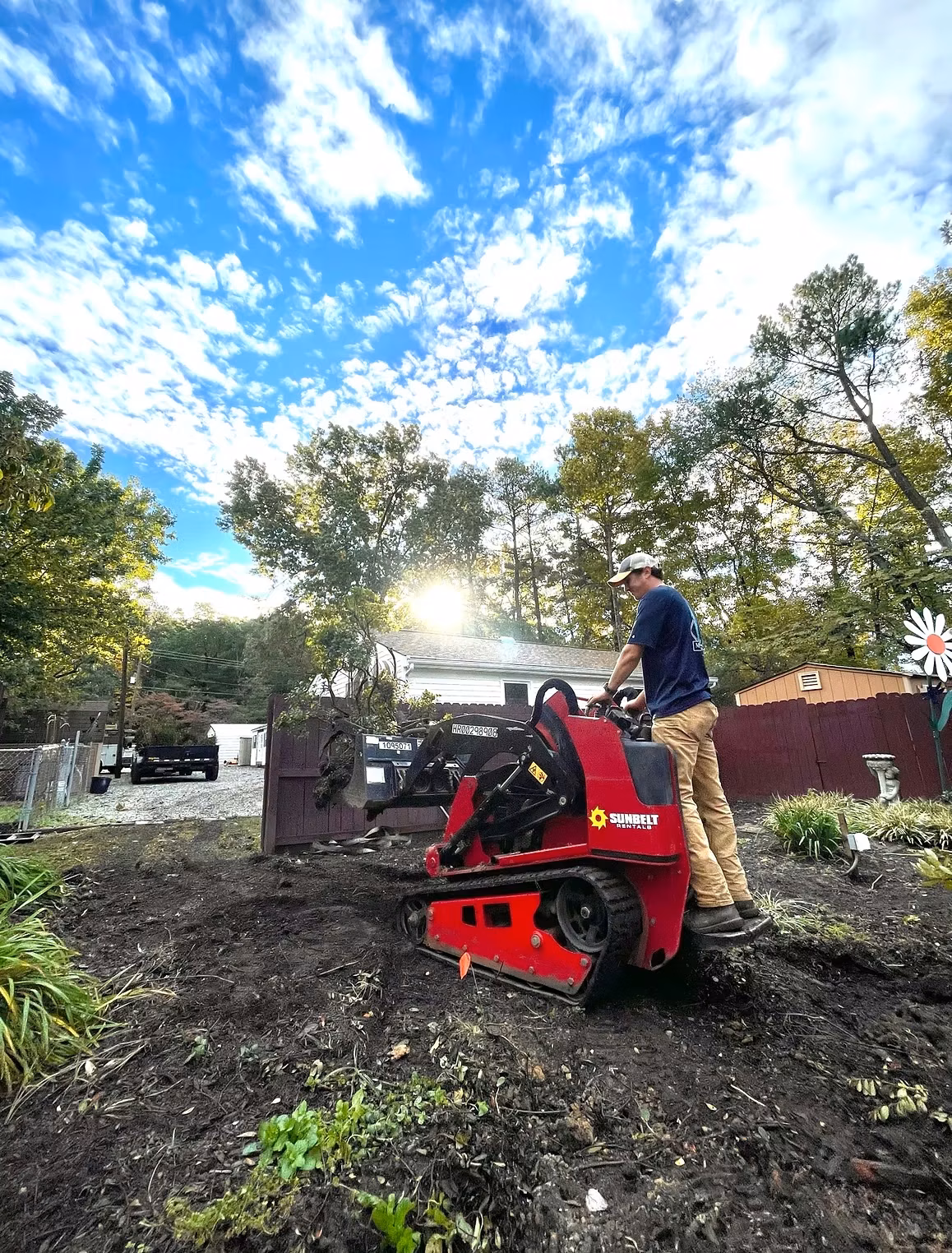 Montgomery Landscape crew member operating a compact track loader during a backyard grading project in Richmond, VA